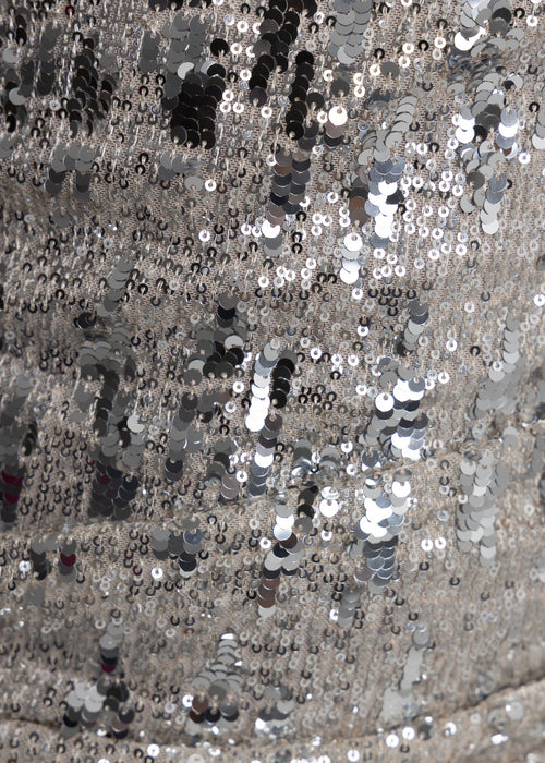 Close up swatch of silver sequins embellished into fabric with different sized shiny silver sequins.