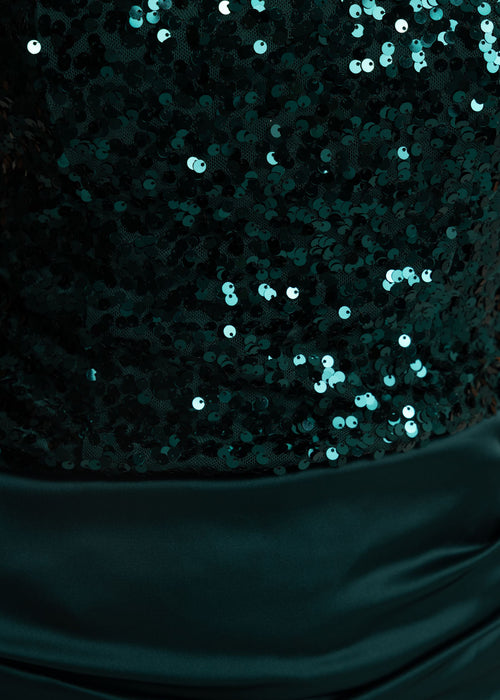 Close up detail of an emerald green sequin mini dress. Bodice fully embellished with emerald green sequins and a satin ruched skirt overlay .