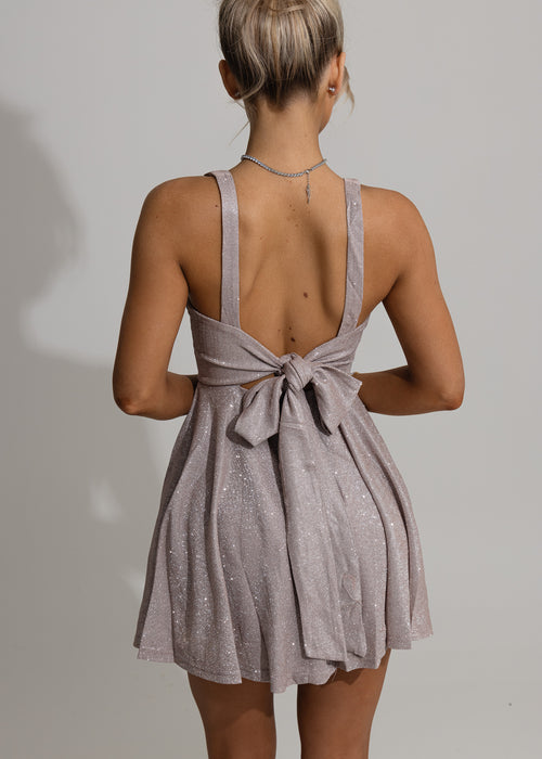 Women's pink glittery skater mini dress with square neckline and pleated skater style skirt. Model is 5ft2' and wears a size XS 6.