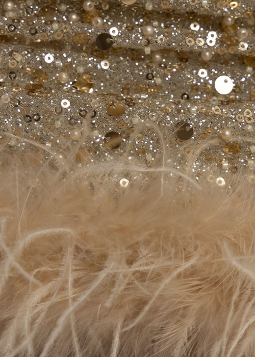 Close up swatch on gold sequin mini dress with feather trim.