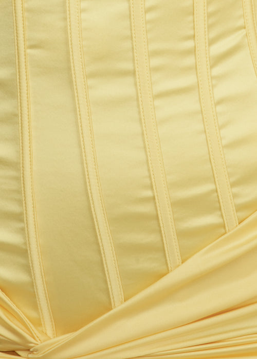 Close up of pastel yellow satin fabric on prom gown.