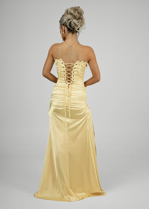 Strapless gown with open back, ruched detailing and corset fastening on bodice. 