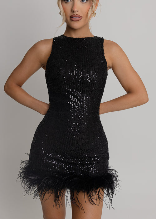 Women's black sequin sparkly mini dress with black feather trim. Bodycon fit with round neckline and open back. Model is 5ft2' and wears a size XS 6.
