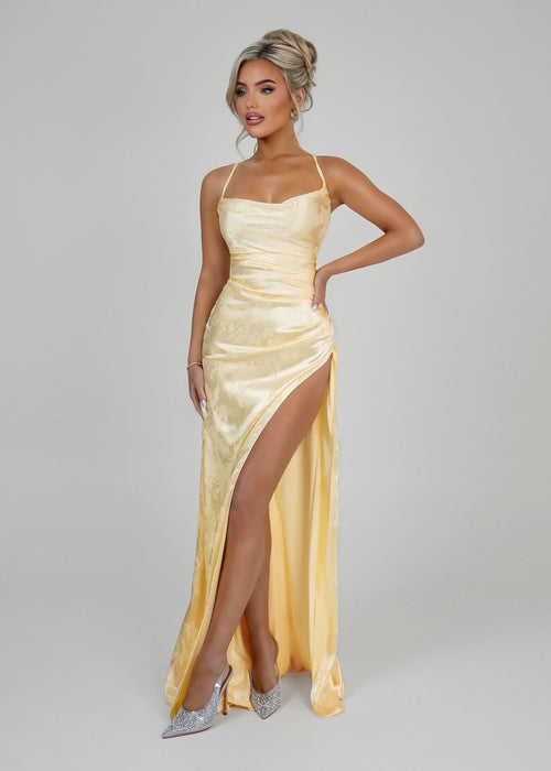 Women's pastel yellow satin prom gown with thigh slit and spaghetti style straps. Figure hugging fit. 