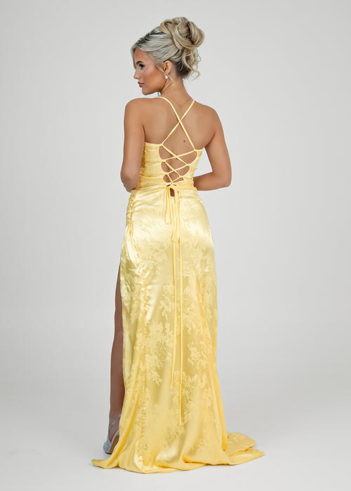 Women's pastel yellow satin prom gown with thigh slit and spaghetti style straps. Figure hugging fit. 
