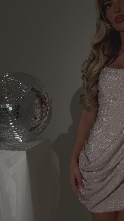 Women's champagne shimmer mini dress with hot fix embellished fabric and drape flowing from strap to waist.